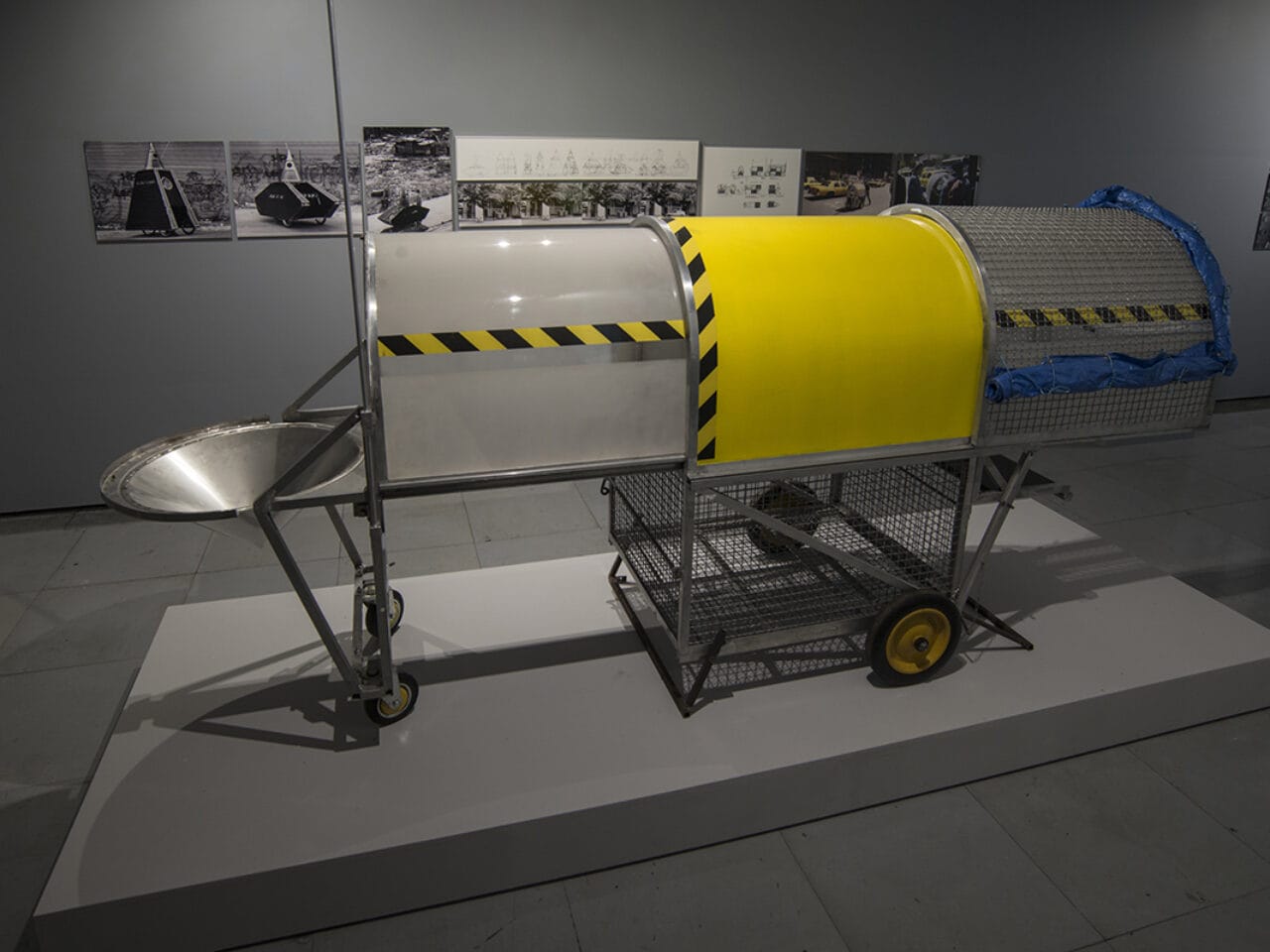 A metal oblong structure on wheels and covered in yellow and black tape.