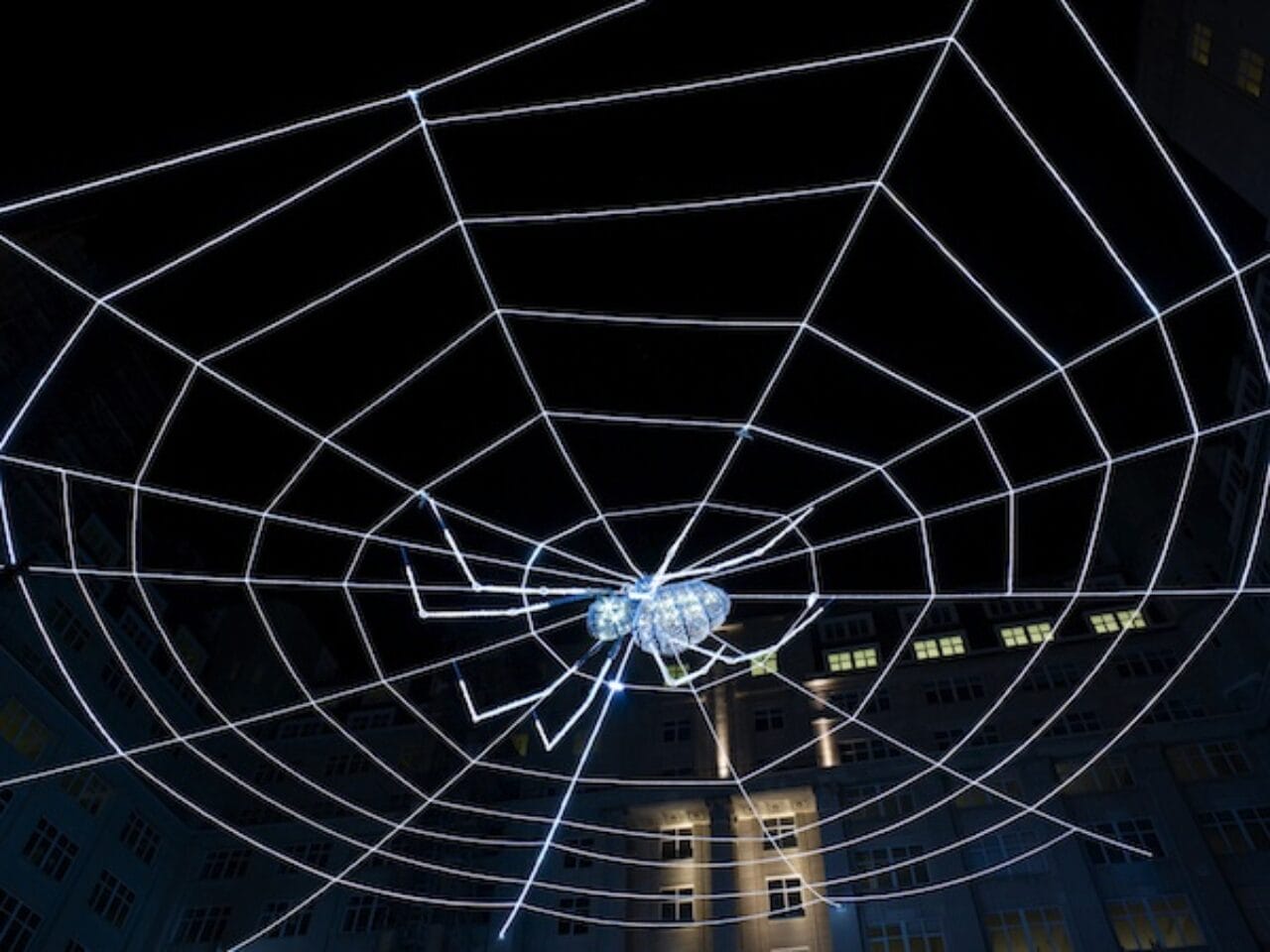 A giant LED lit web hanging above Liverpool's Exchange Flags, with a crystal-studded spider in the center.