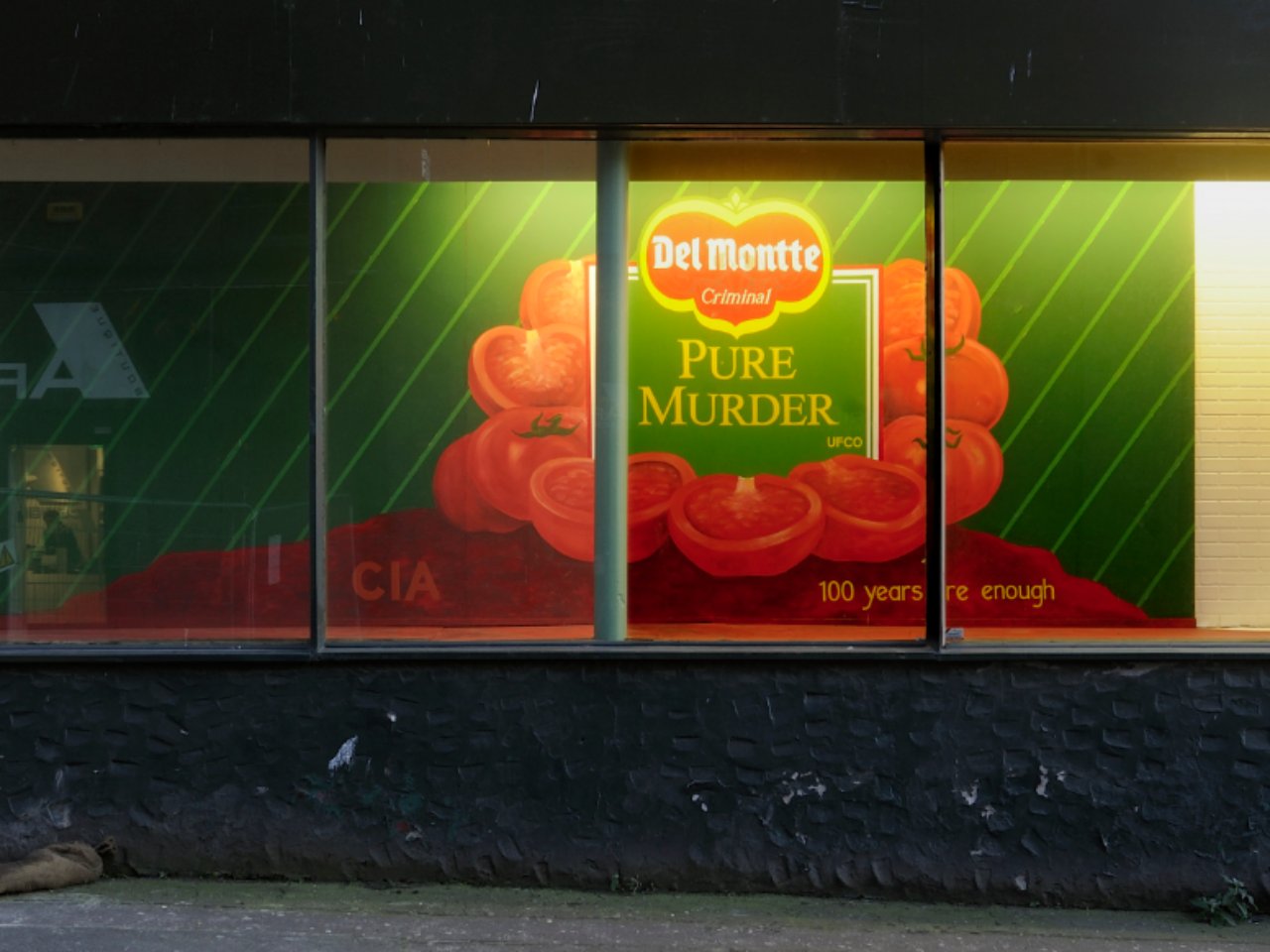 A window display, in the window display is a label for tinned tomatoes covering the entire wall, the label read, pure murder