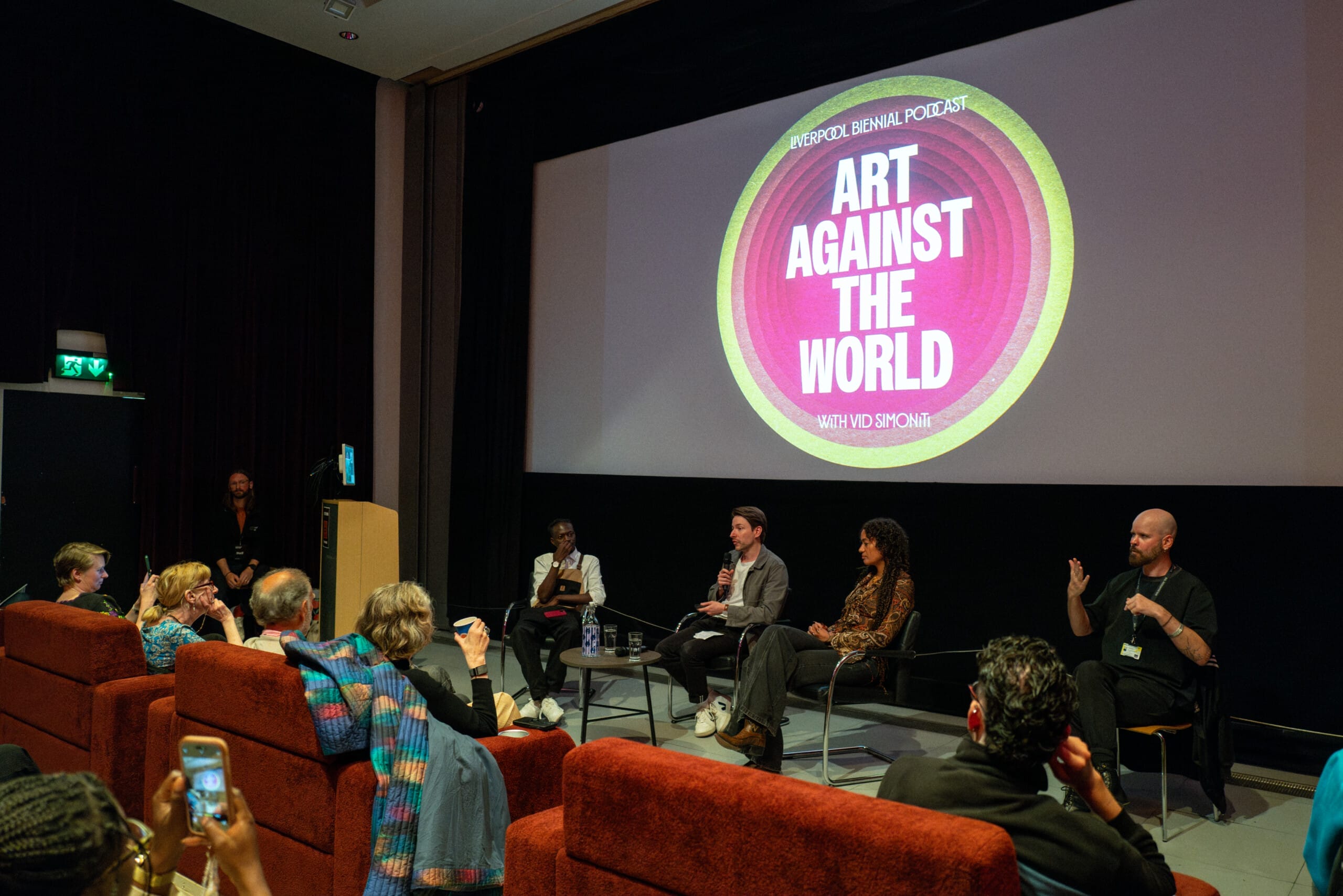a roup of people speaking at a podcast launch